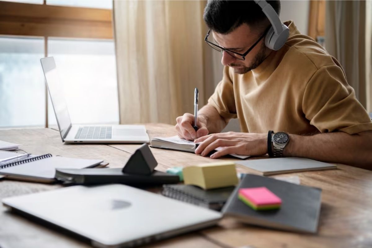 Um estudante em seu escritório escrevendo em seu caderno