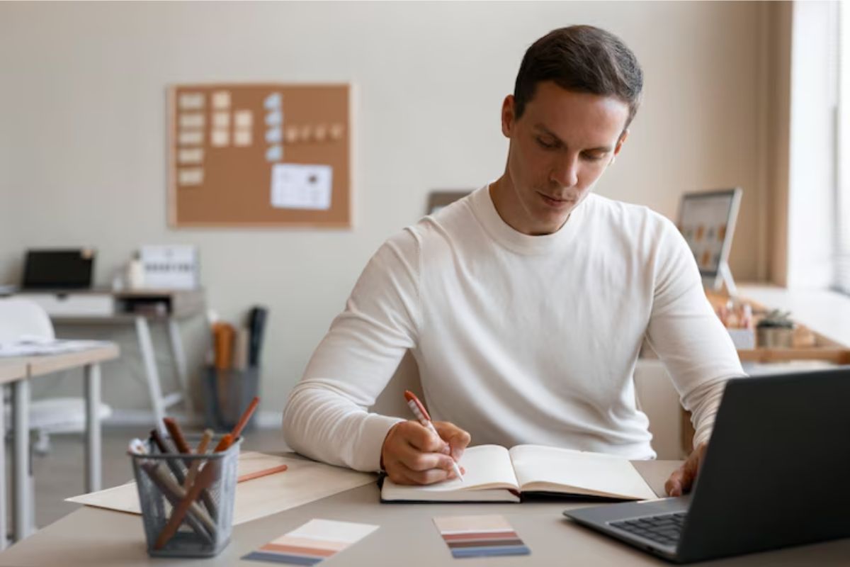 Um aluno em seu quarto está sentado no notebook se inscrevendo para o Vestibular FAETEC 2025