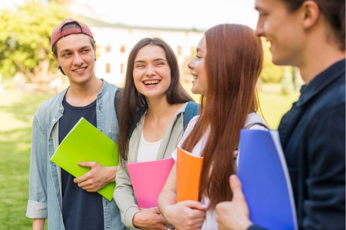 Quatro alunos no jardim da escola conversam acerca do Vestibular ETEC 2025