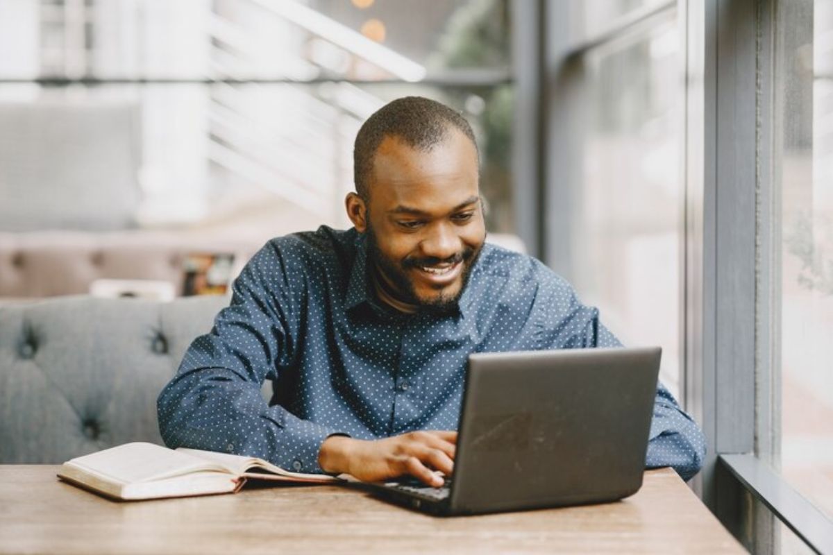 Um estudante sentado usando o seu notebook para fazer a Dilatação FIES 2025