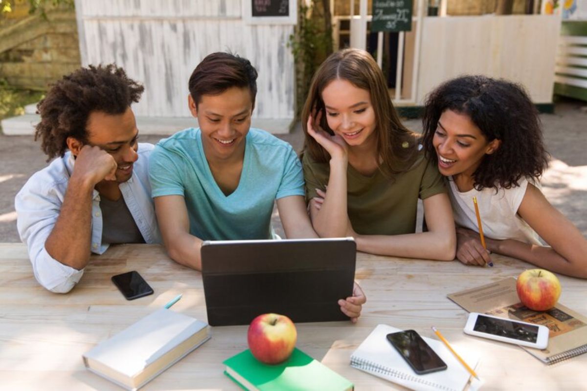 Um grupo de quatro estudantes olha atentamente para o notebook, acessando o SisFies 2025