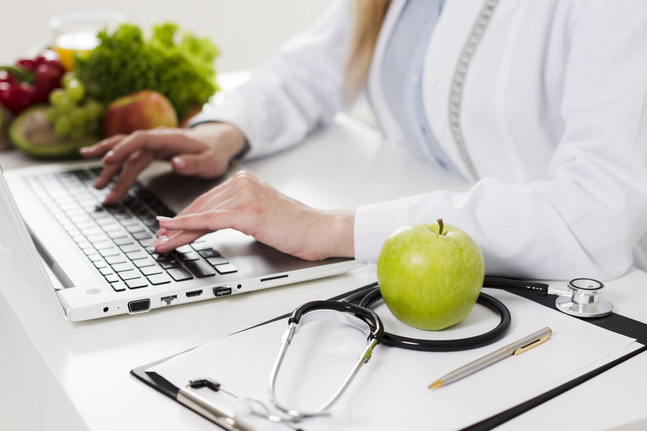 Close de uma nutricionista trabalhando em seu notebook