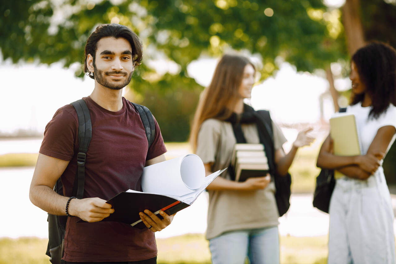 Jovem estudante no campus com colegas ao fundo