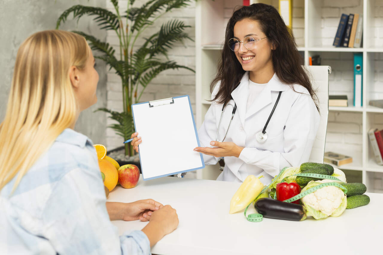 Nutricionista mostra planejamento de dieta a paciente 