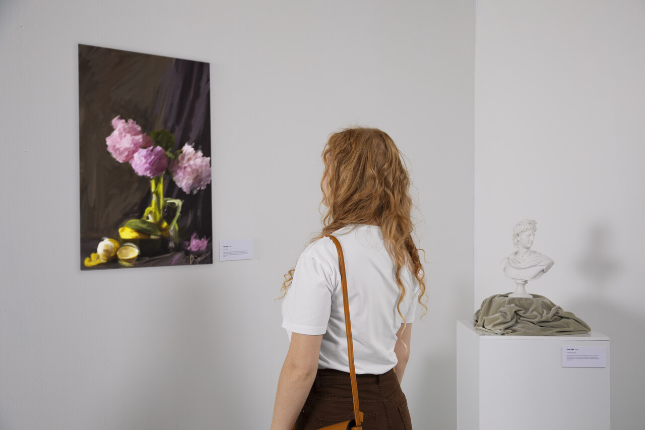 Jovem observa obra de arte em um museu