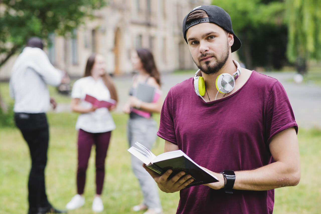 Jovem estudante no campus com colegas ao fundo 