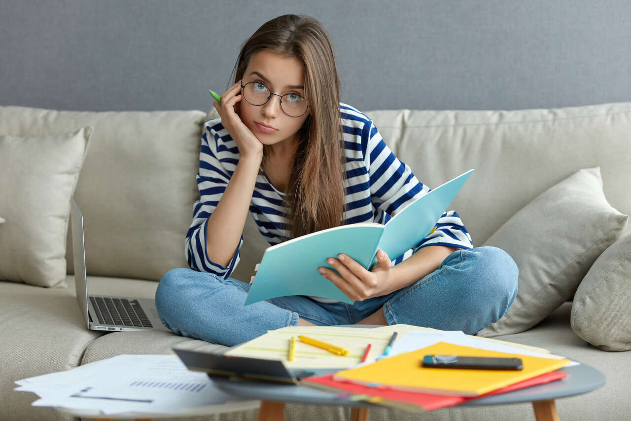 Jovem estudando com expressão pensativa