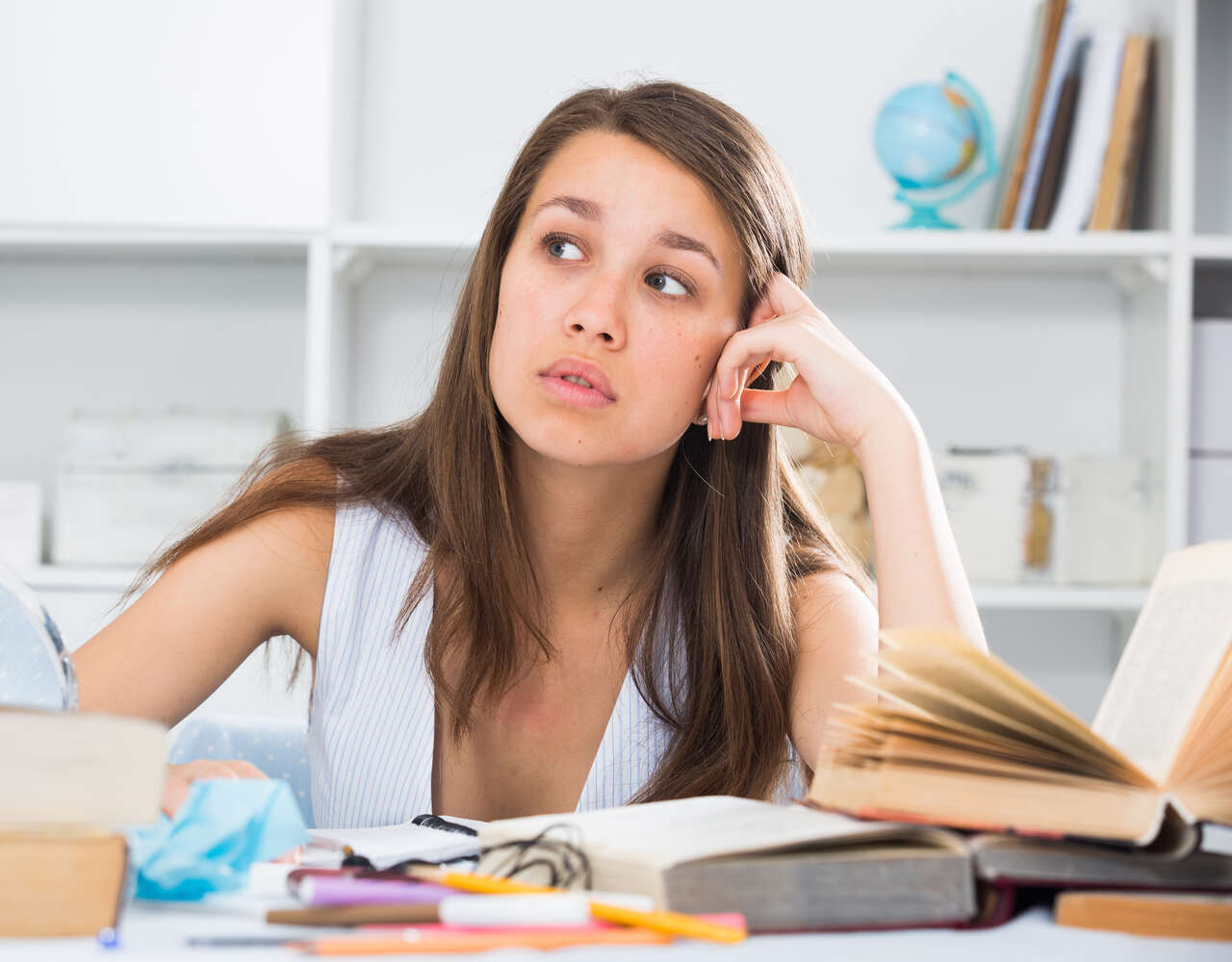 Jovem estudando com expressão pensativa 