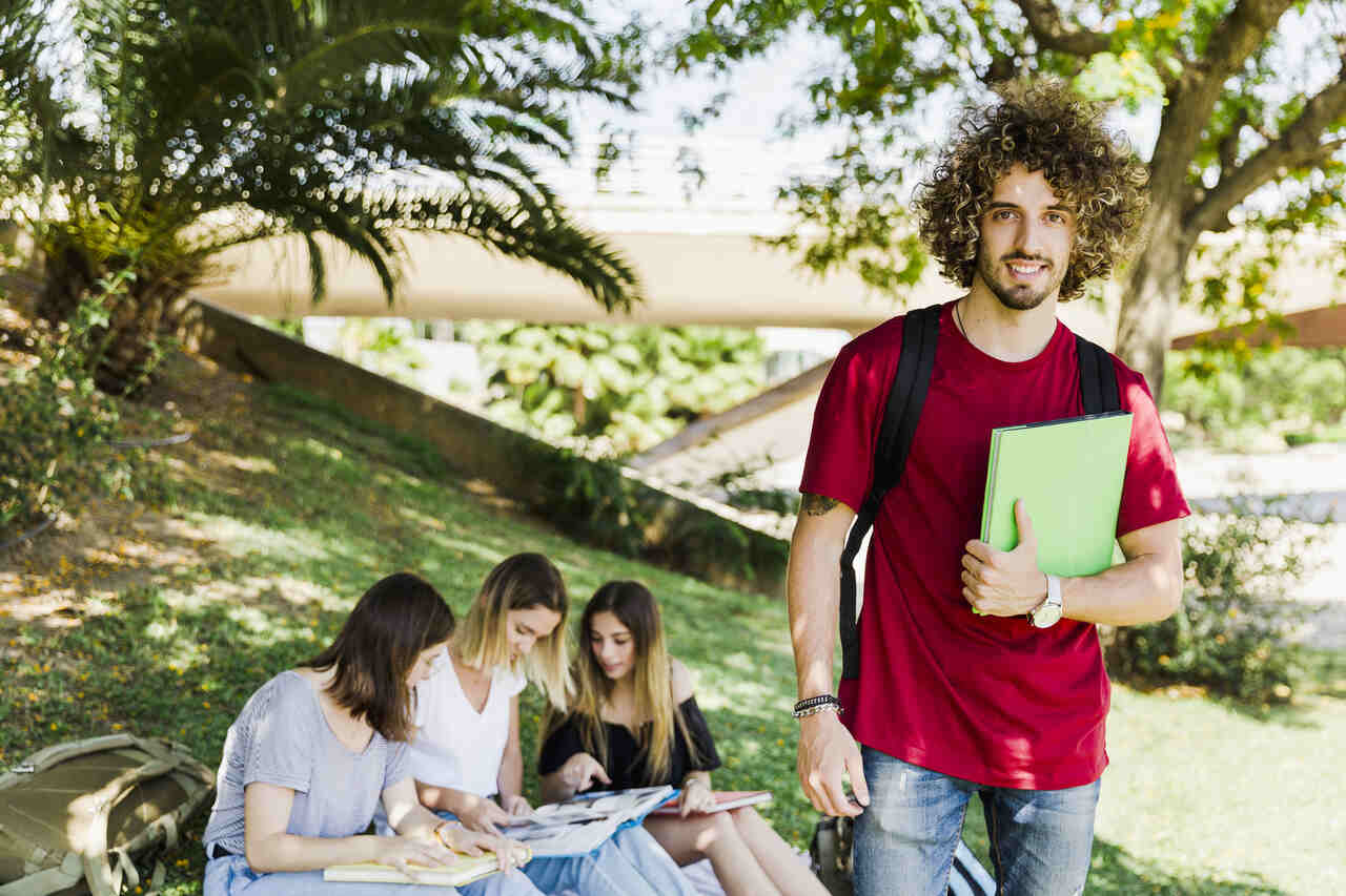 Jovem estudante no campus com colegas ao fundo 