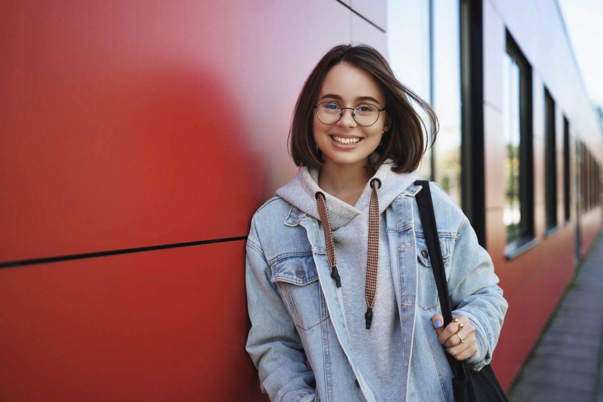 Jovem estudante posa no campus da universidade 